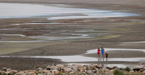 Park visitors walk along a section of the Great Salt Lake that used to be underwater (Representative Cover Image Source: Getty Images | Photo by Justin Sullivan)