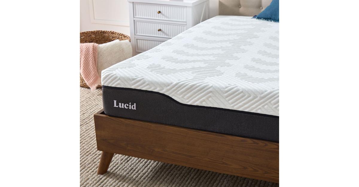 Lucid mattress on a wooden platform frame with a rug, dresser, and hamper.