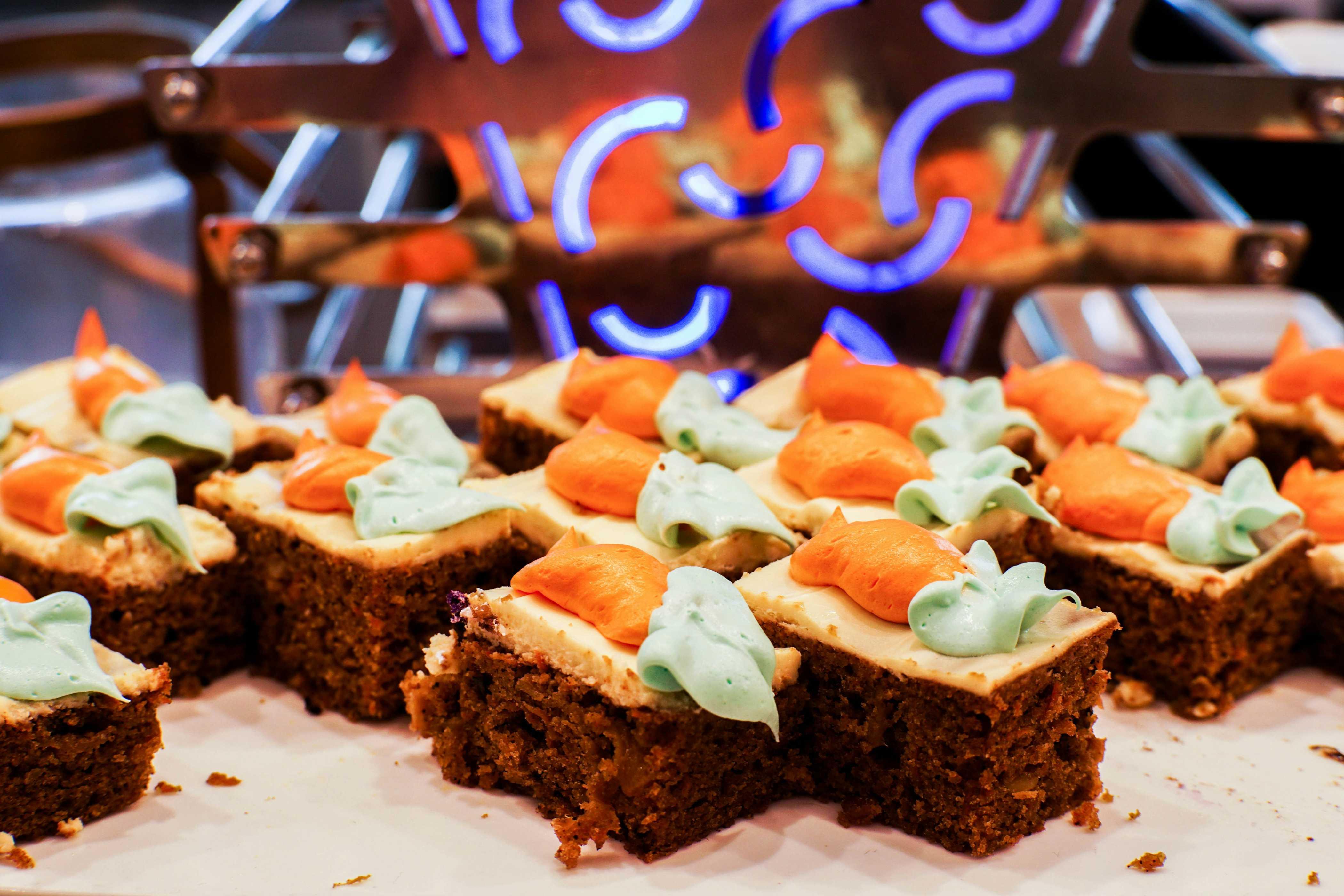 A series of mini carrot cakes are pictured and decorated with icing-based carrots on top.