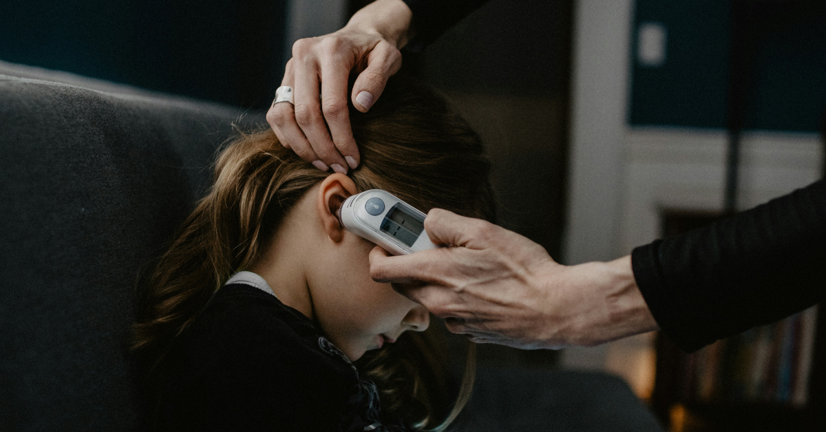 A woman takes the temperature of her daughter