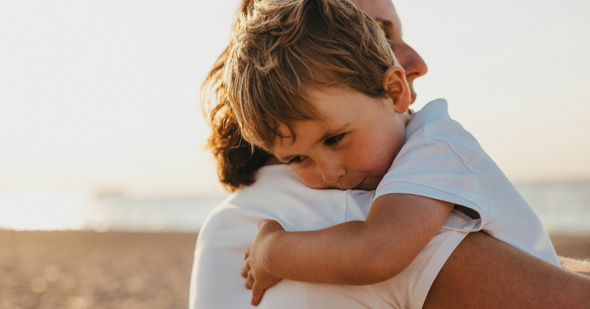 A little boy clings to his parent