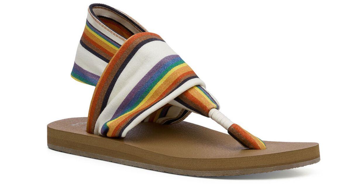 A brown and rainbow sandal. 