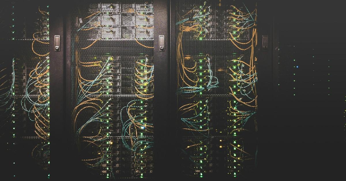 Wires and lights appear locked behind the cages of a data center