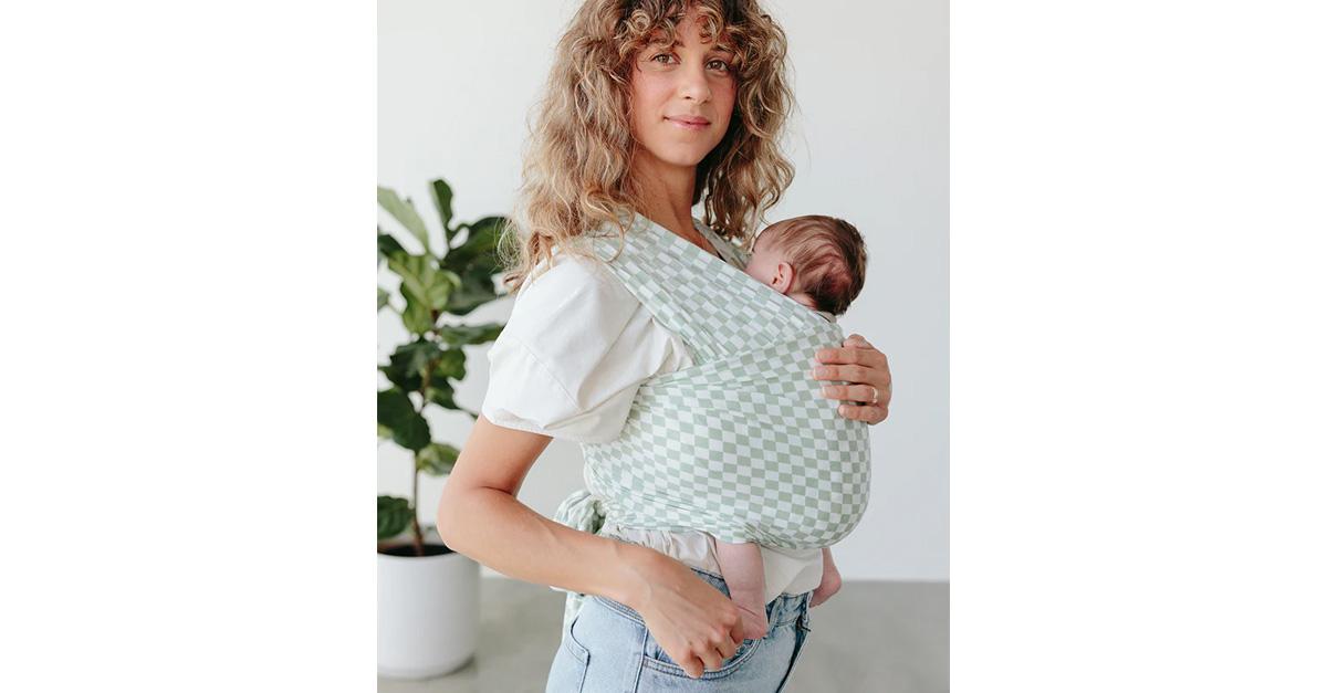 mom holding newborn in checkered baby carrier wrap