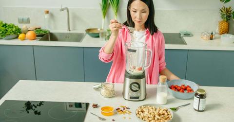 The woman adds ingredients to prepare a nutritious drink in the blender. (Representative Cover Image Source: Pexels | Yaroslav Shuraev)