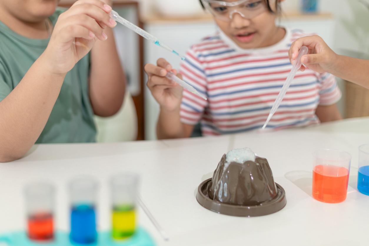 Kids working on a baking soda volcano experiment together