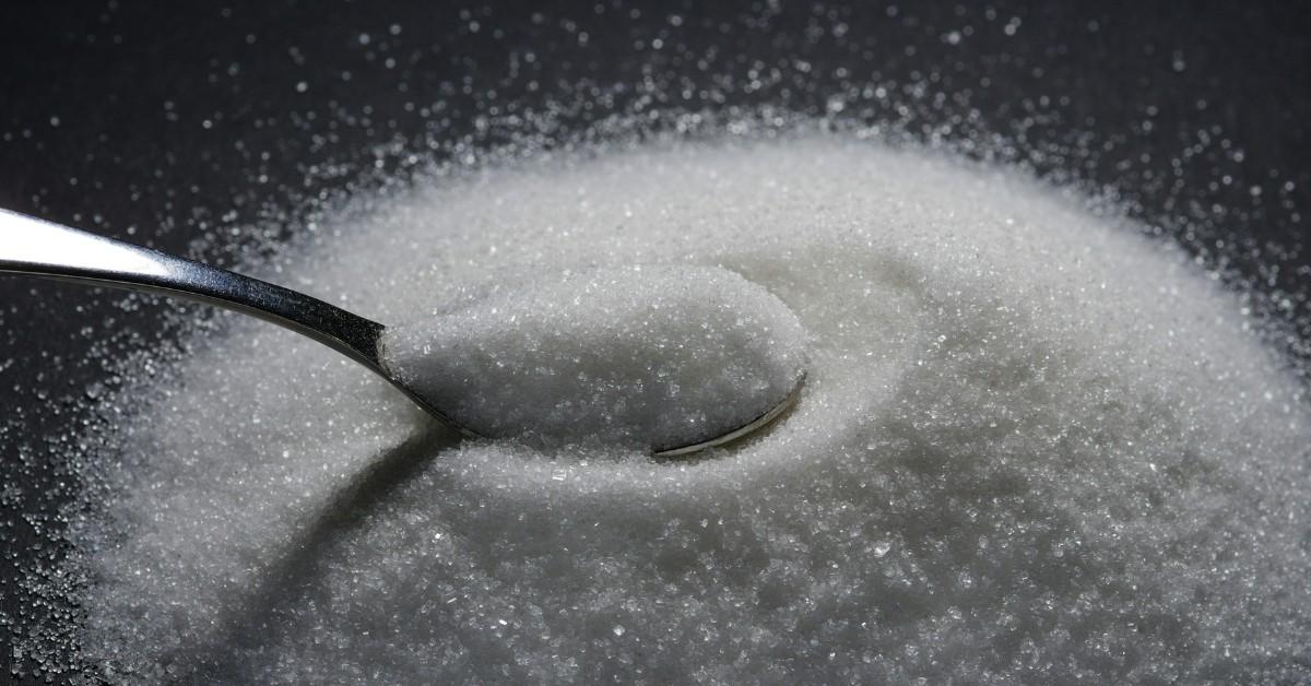 A spoon sits in a pile of white powder that looks like sugar