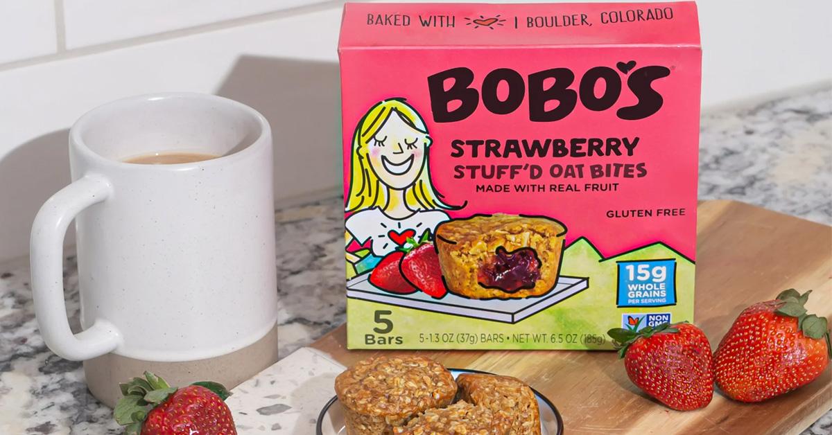 box of oat bites on countertop with strawberries and a cofee mug