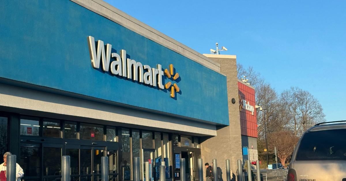 People walk around in front of a Walmart