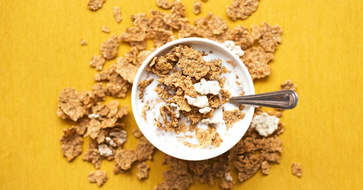 A bowl of breakfast cereal sits against a yellow background