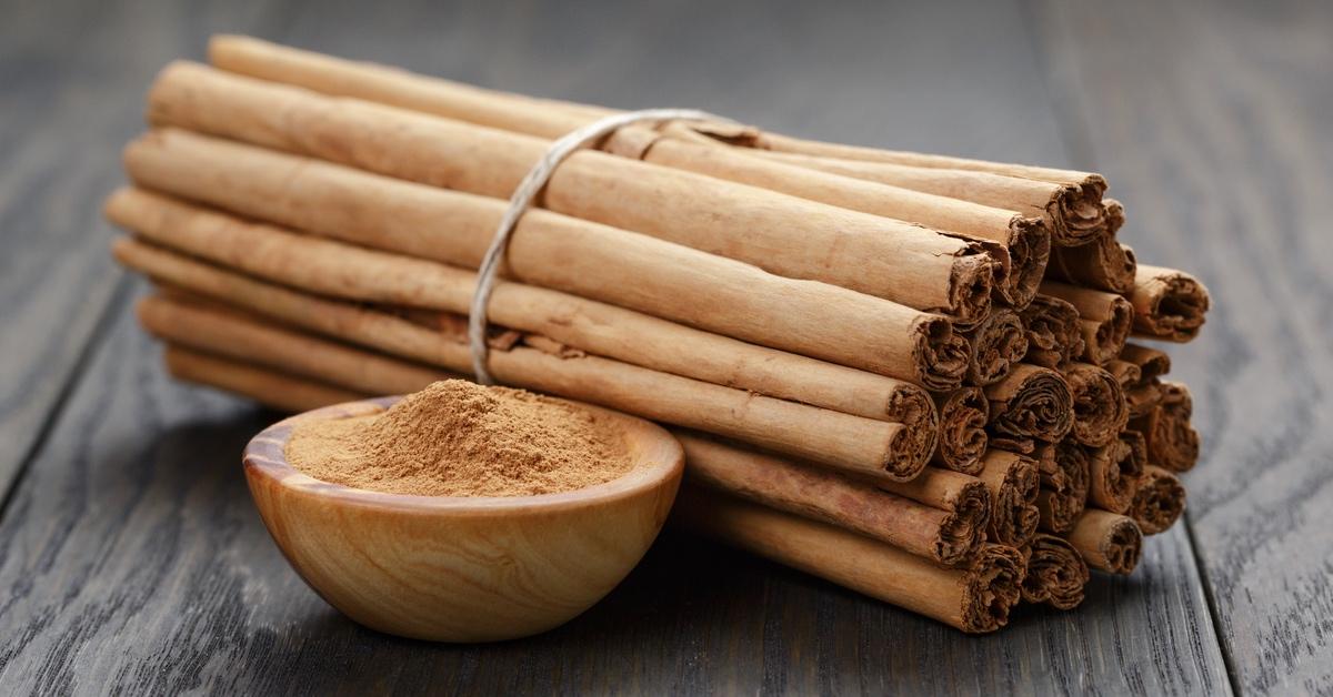 Bowl of cinnamon powder and cinnamon sticks.