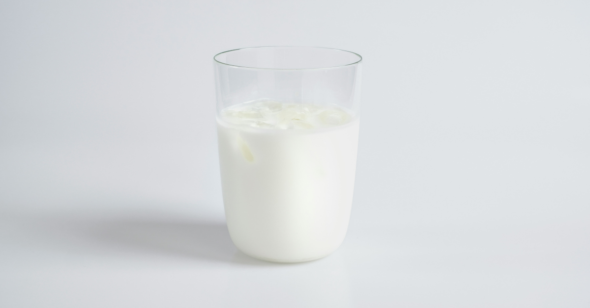 A cup of milk sits on a white background