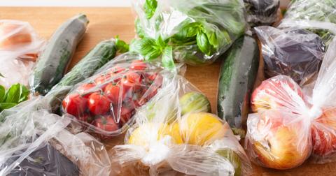 Fruits and vegetables bagged in grocery store plastic bags.