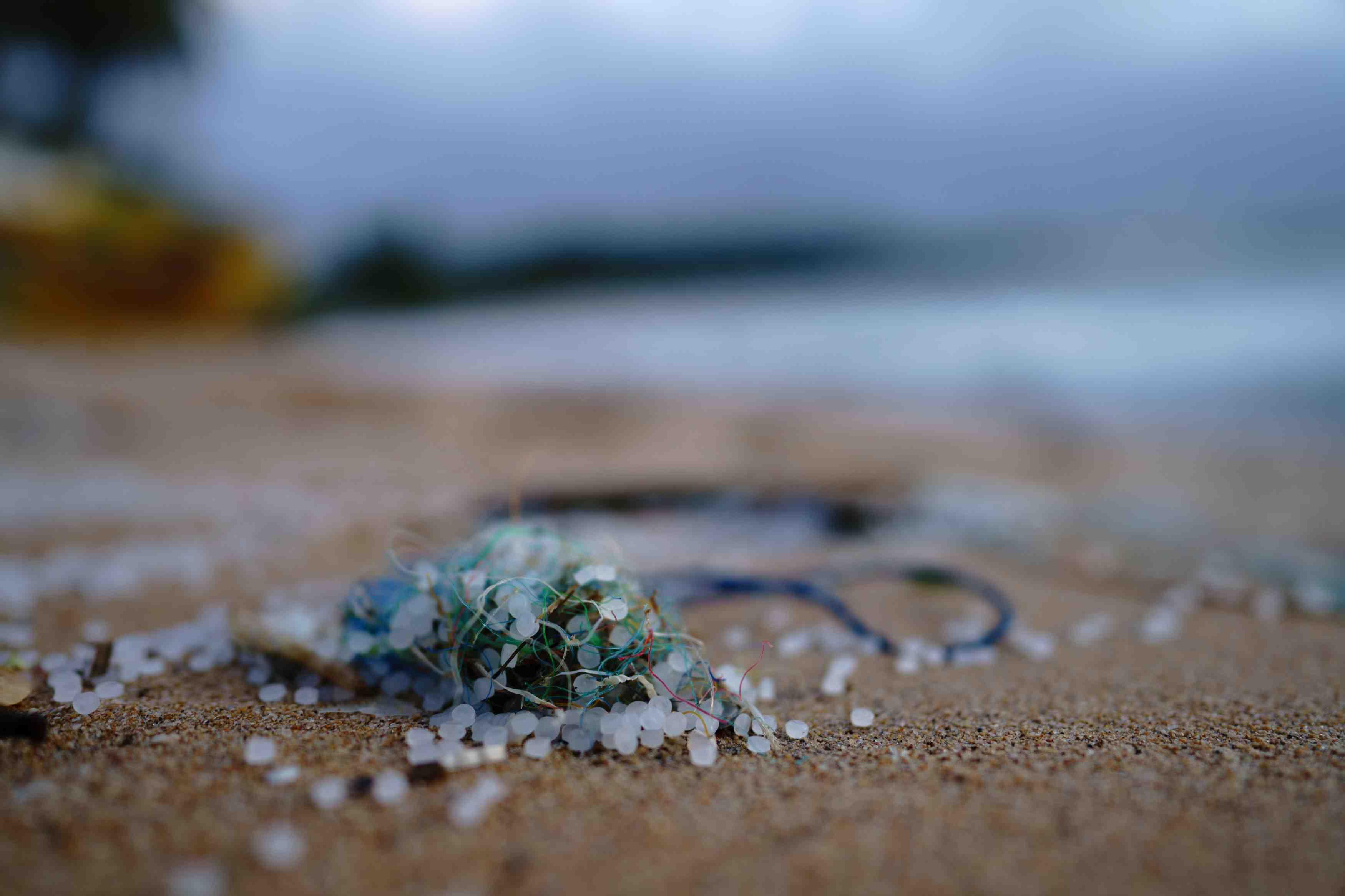 Plastic trash is pictured washed onto the sand on a beach.