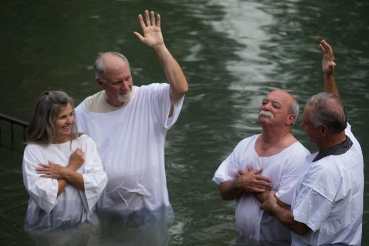 people dressed in white to be baptized in the river