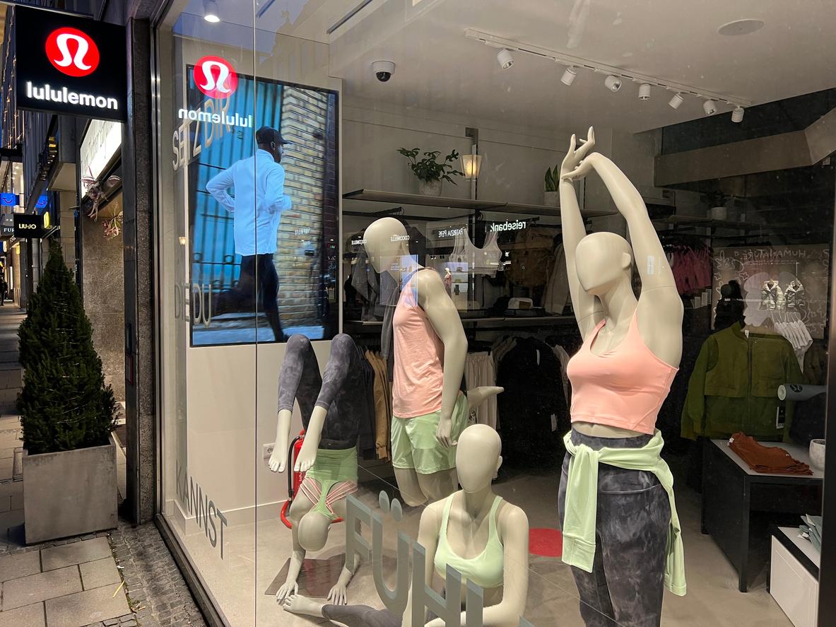 A close up view of mannequins in a display window wearing Lululemon athletic clothes.