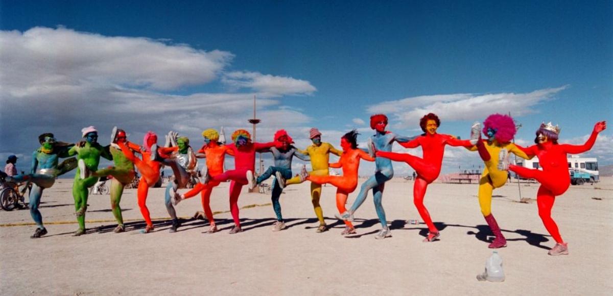 group of people painted in bright colors at Burning Man