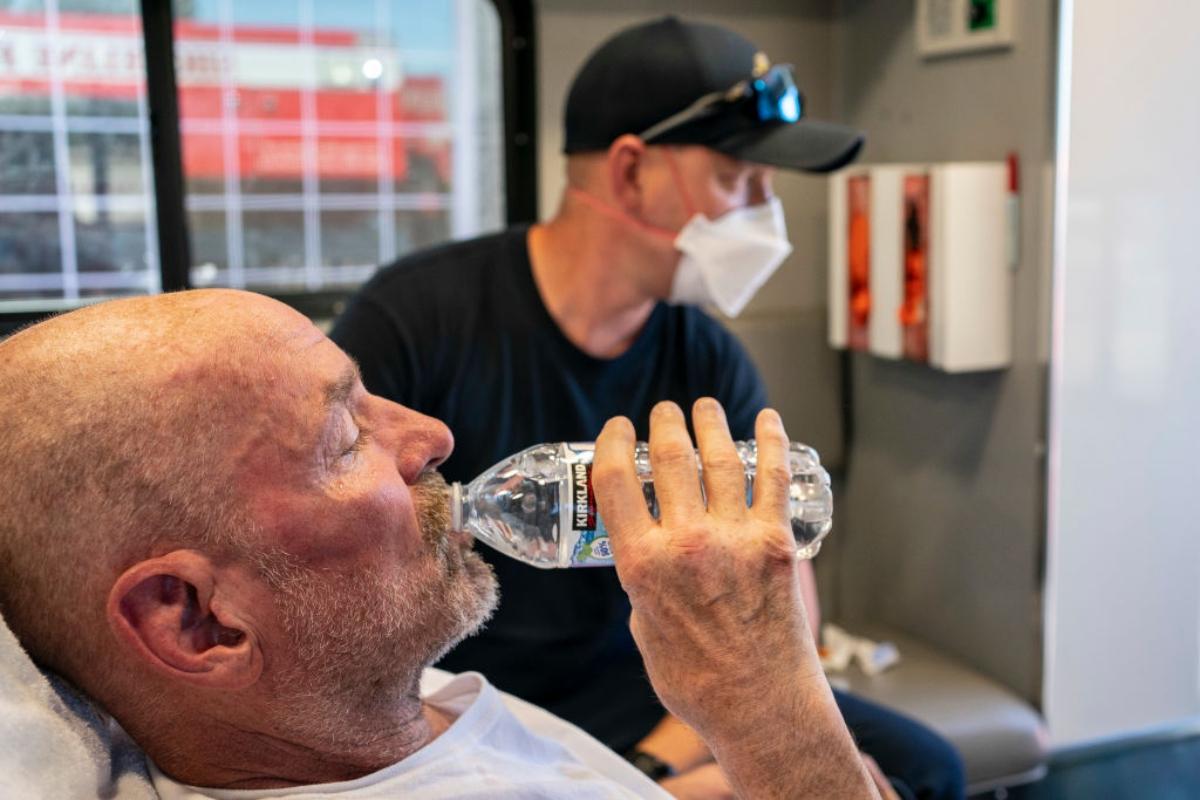 man drinks water in heat wave