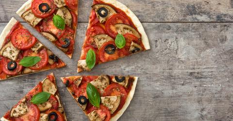 Four pizza slices on a wooden table.