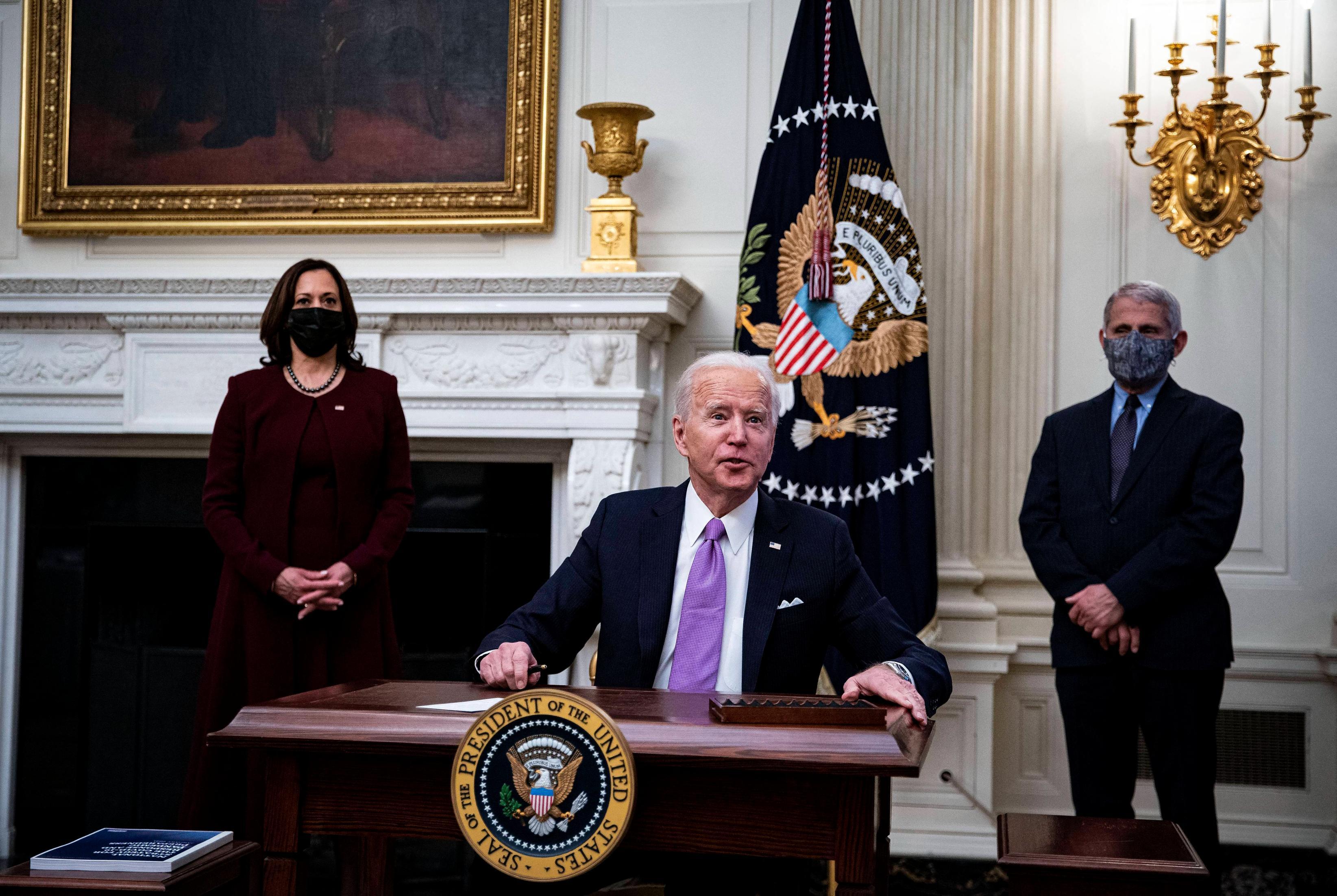 President Joe Biden delivers a speech in the State Dining Room of the White House with a masked Dr. Anthony Fauci and masked Vice President Kamala Harris behind him in January 2021.