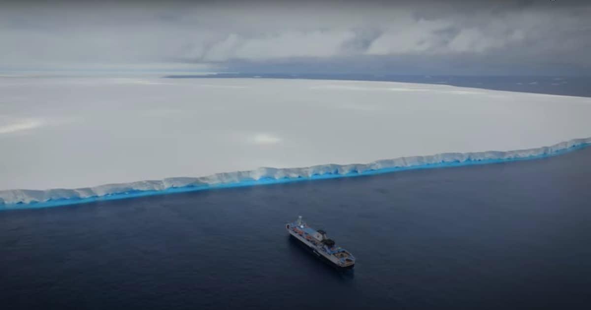 Wide-angle image of the massive A23a iceberg in relation to a research vessel.