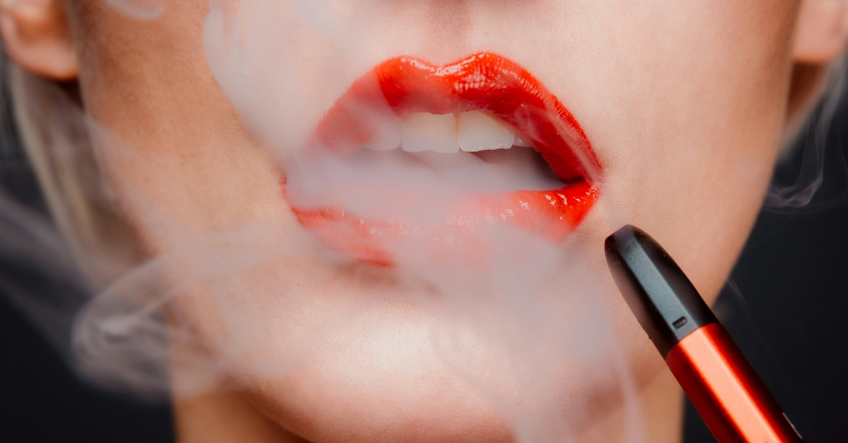 A woman exhales smoke from a vape