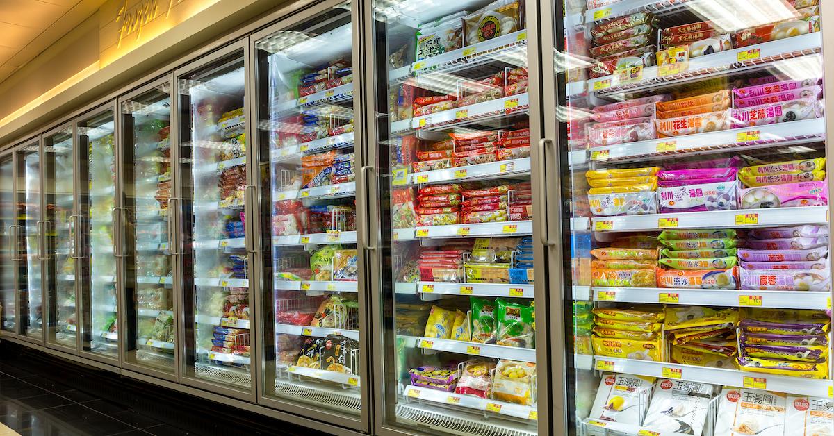 Supermarket aisle of freezers filled with packaged foods
