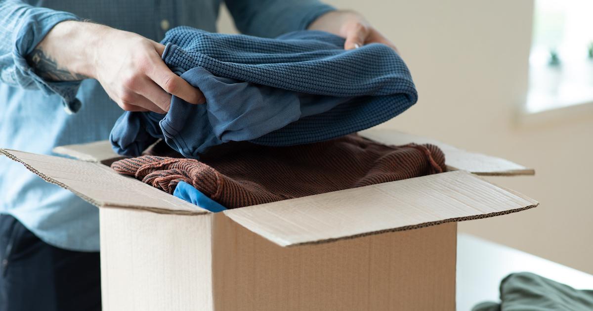 Person puts sweaters in a cardboard box