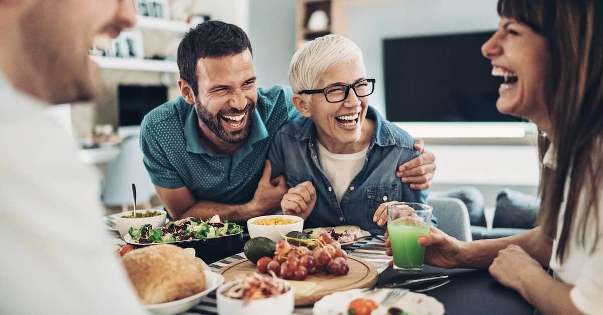 Group of friends laughing and enjoying a vegan meal together