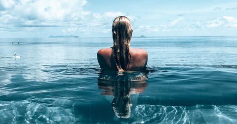 Blonde woman in a pool, photographed from behind