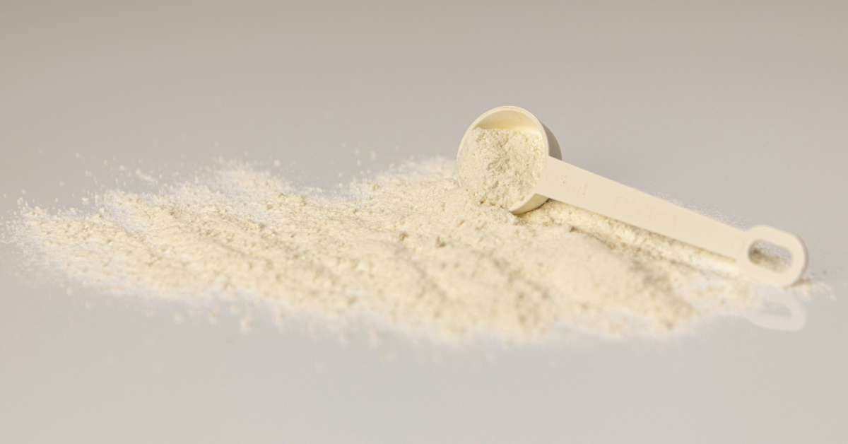 Formula powder is spread out on the counter with a measuring scoop 