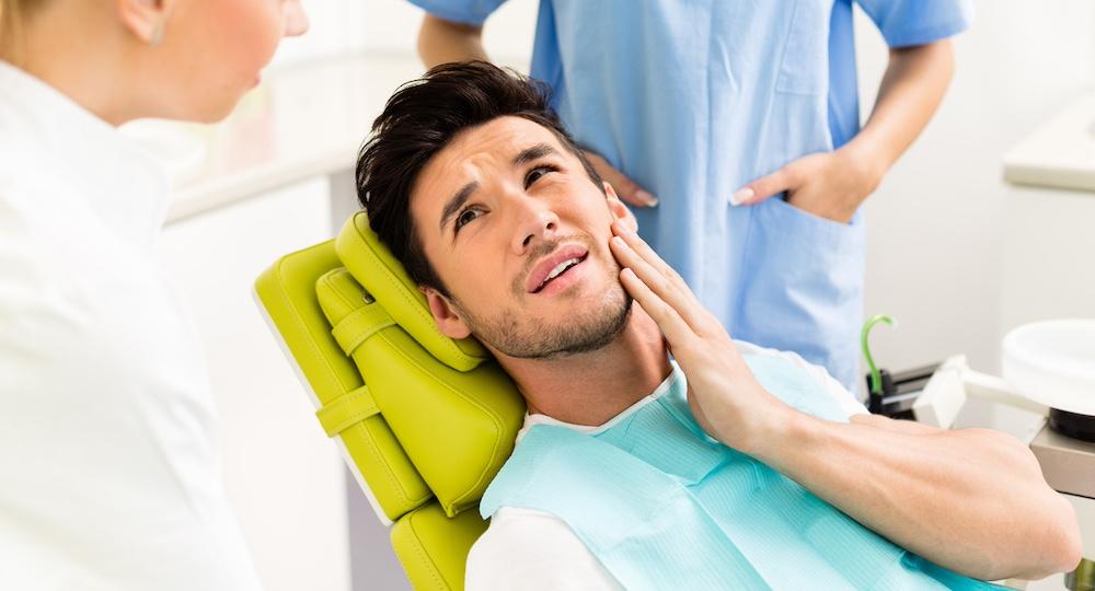 A man at the dentist because of tooth pain.