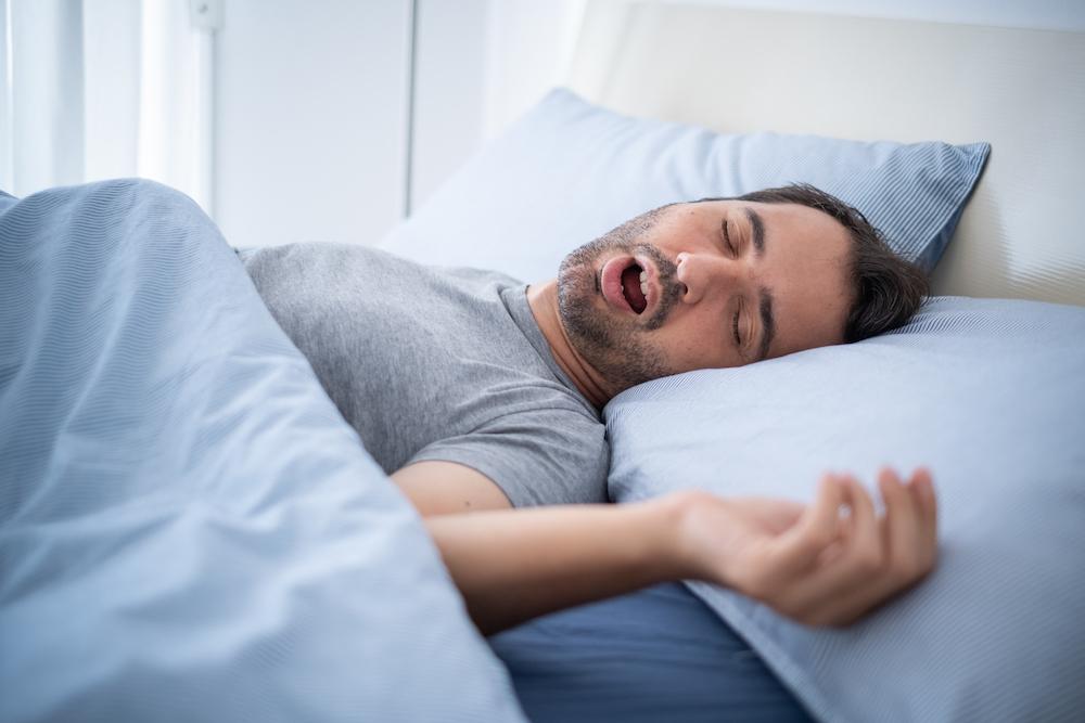 A man snoring in bed. 