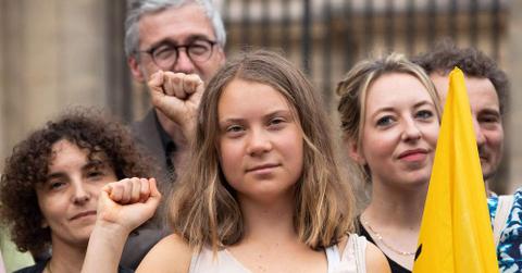 Greta Thunberg holding up a fist with other people