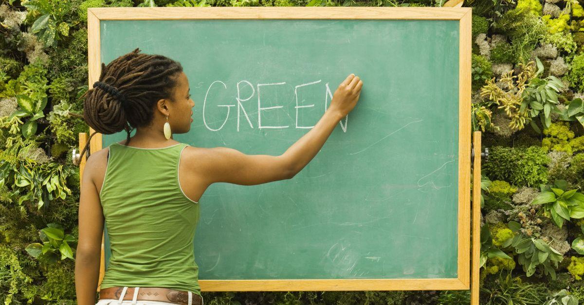 Woman writing on chalkboard outside