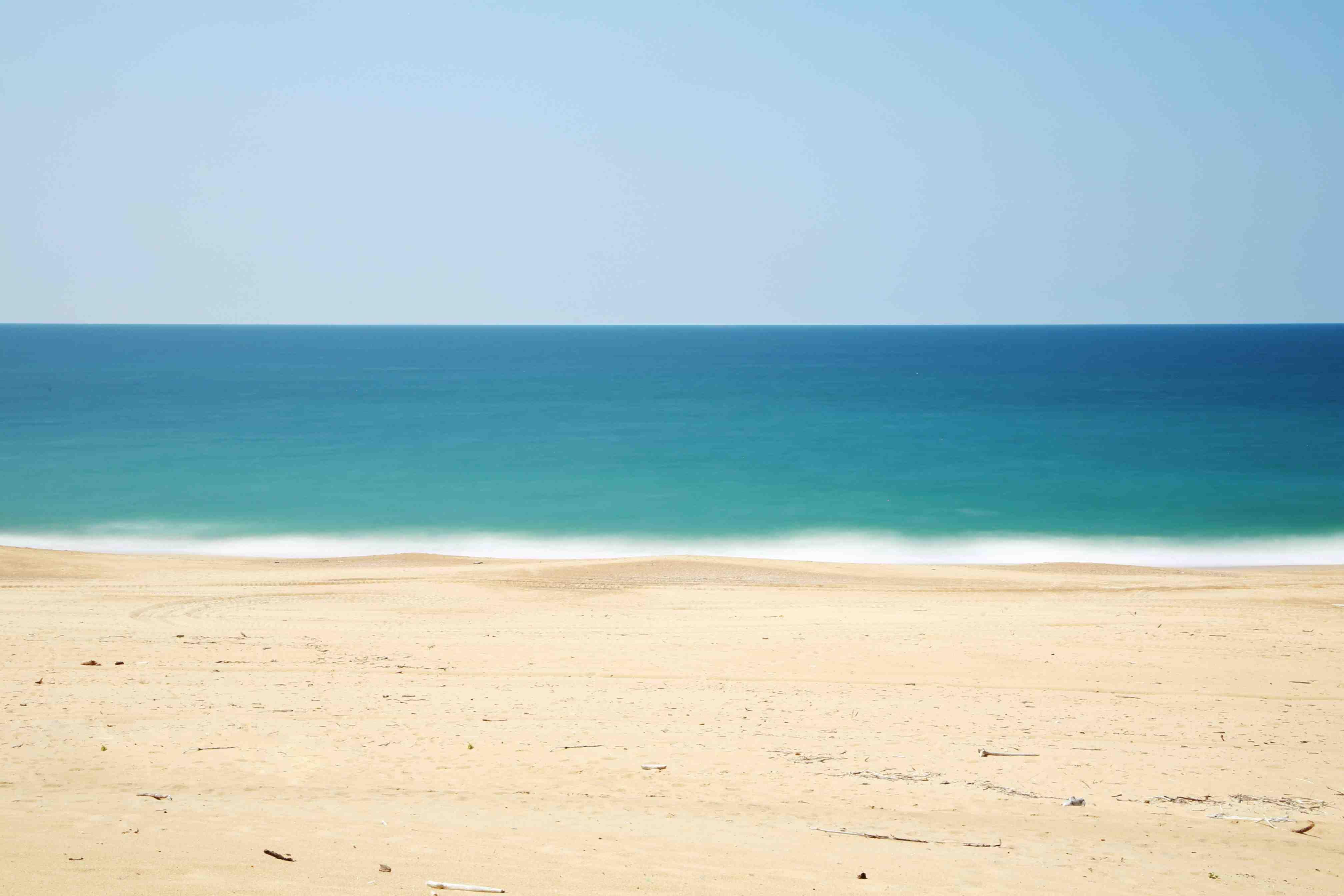A beach is pictured on a sunny day.