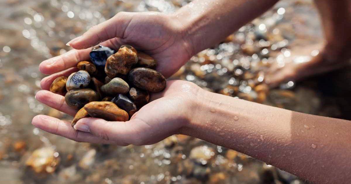 An individual picking up beautiful stones on the beach in Jurrasic Coast, Dorset, United Kingdom. (Representative Cover Image Source: Getty Images | Imgorthand)