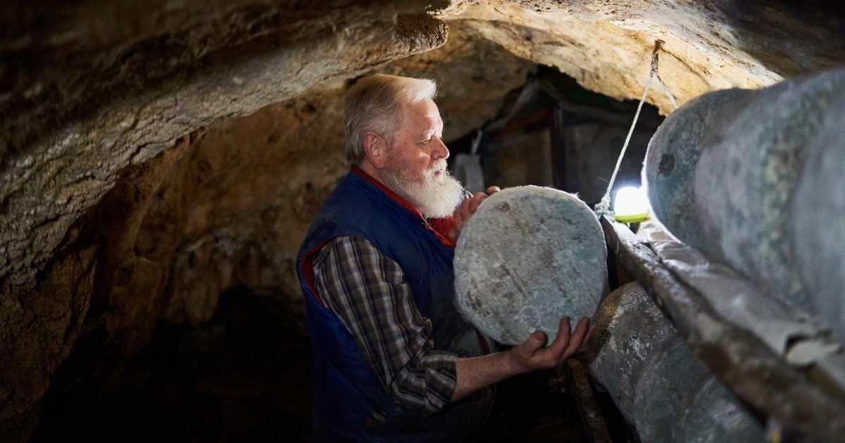 An aged farmer is arranging artisan cheese for curing in a cave. (Representative Cover Image Source: Getty Images | Abraham Gonzalez Fernandez)