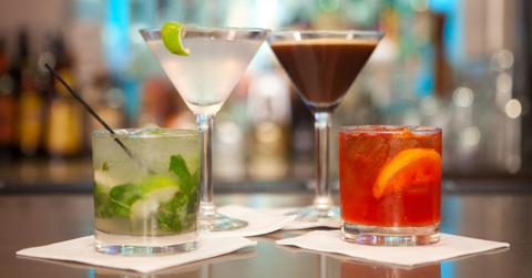 Several mixed drink sit atop a bar