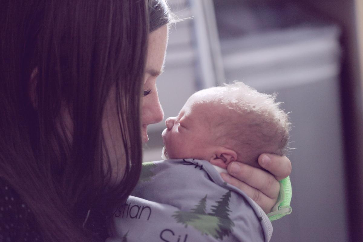 Woman holds newborn baby.