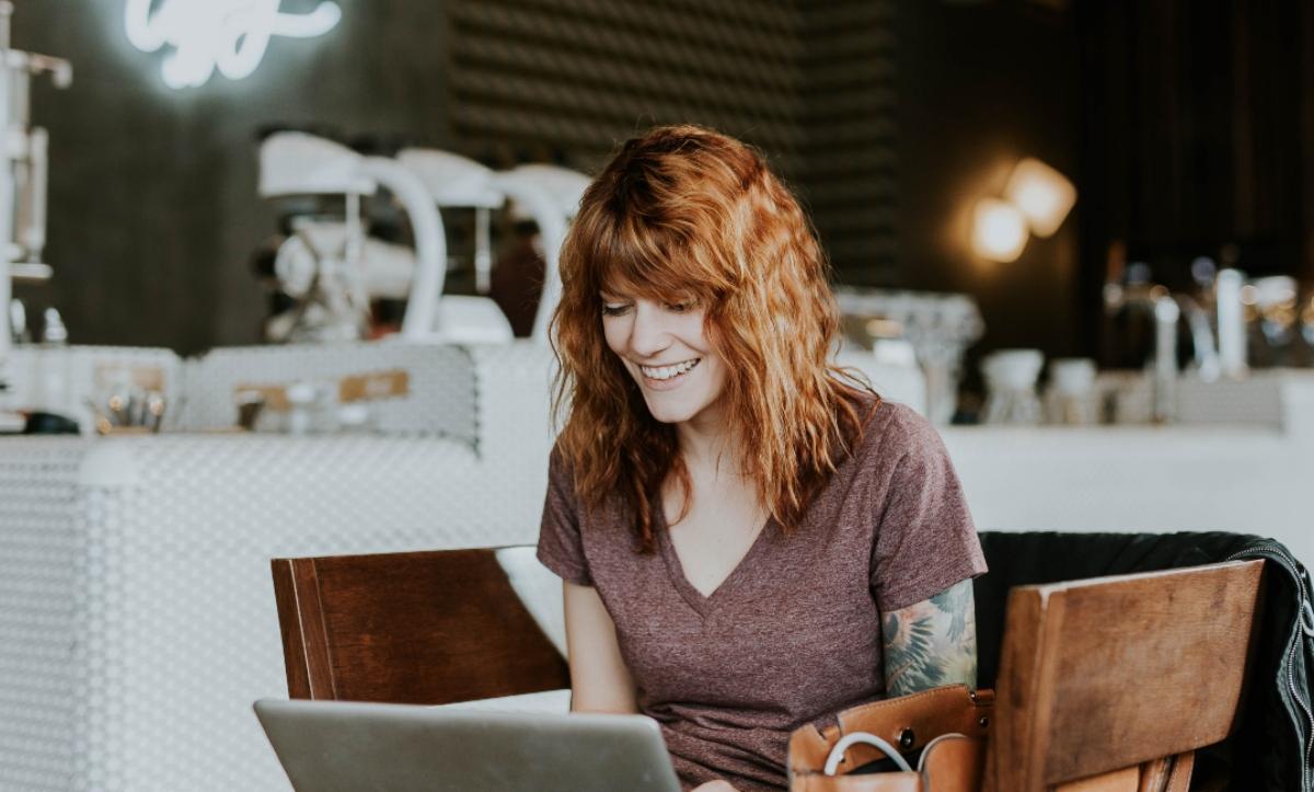 red-haired woman working on laptop 