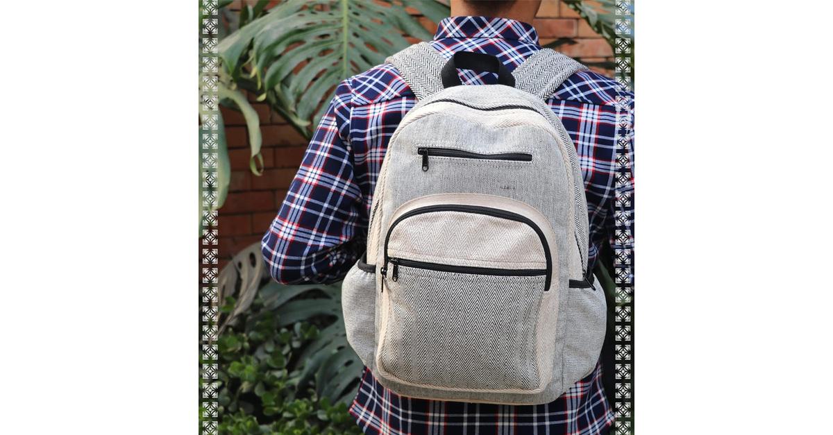 Man in plaid shirt wearing a grey backpack