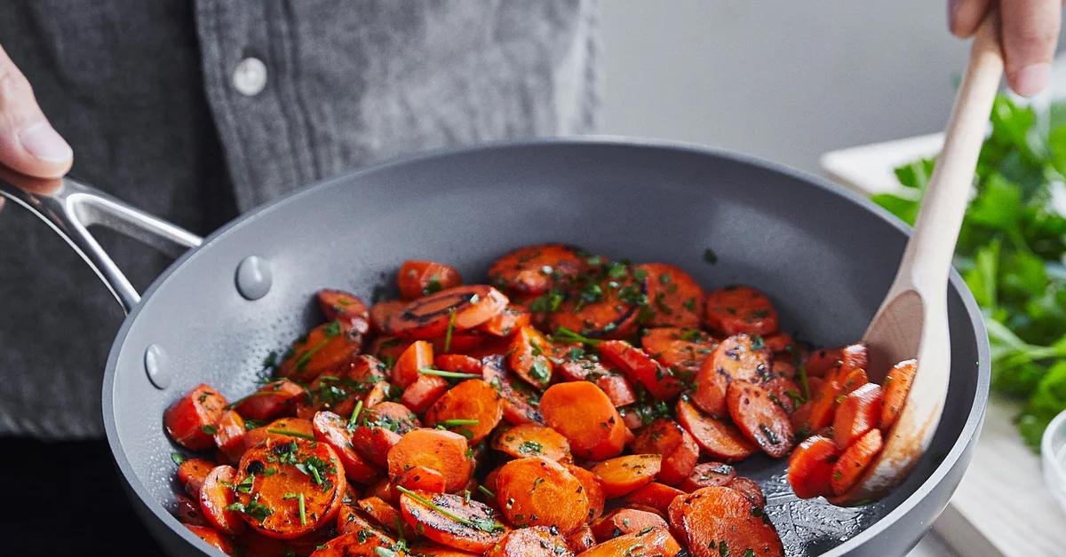 man cooking vegetables in a pan.