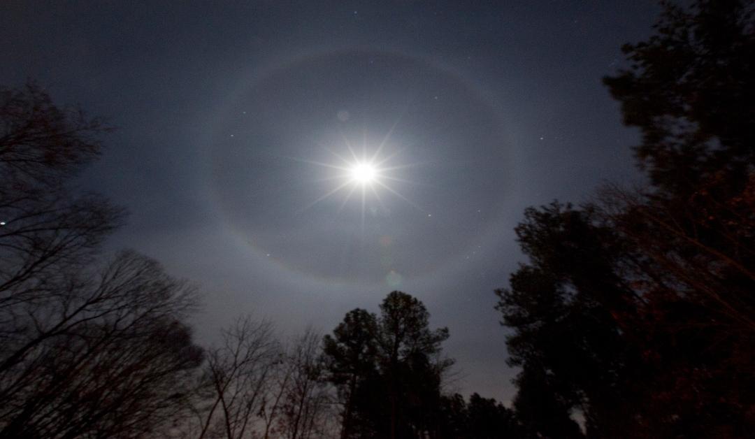 A ring is pictured around the full moon in the night sky