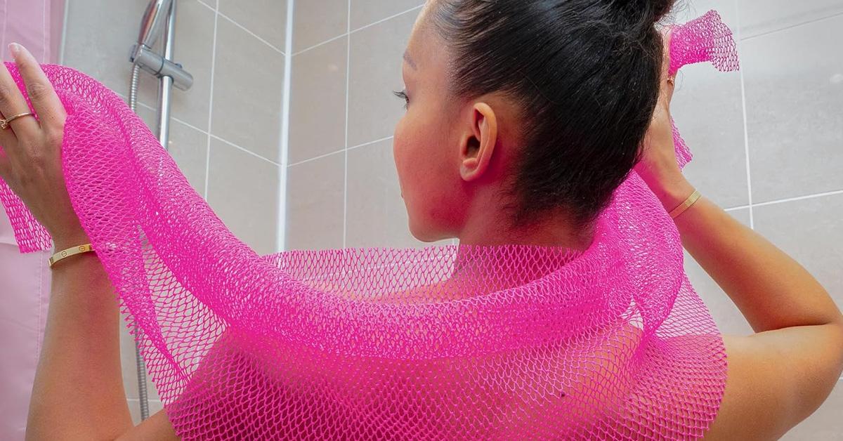 a woman using a pink African net sponge in the shower