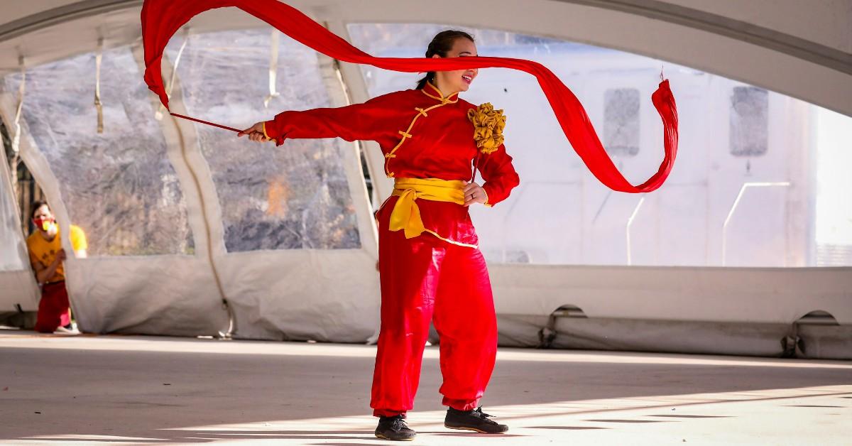 A woman in red performs a traditional dance during an Orlando, Florida Lunar New Year celebration