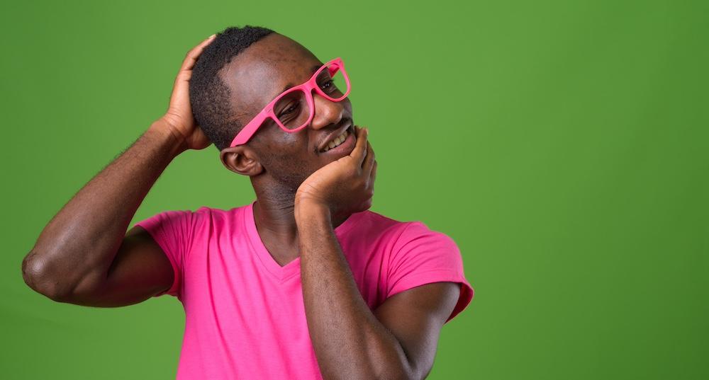 A man cracking his neck against a green background. 