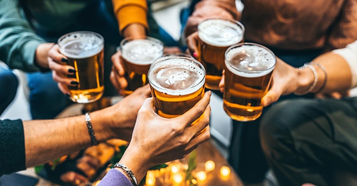 Group of five friends toasting glasses of beer at brewery.