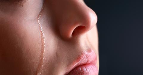 A close. up photo of a tear rolling down a person's cheek.