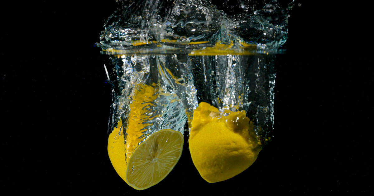 Two lemon halves are dropped into water